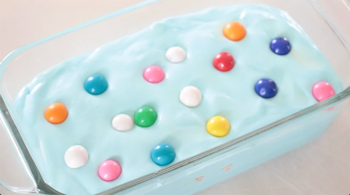 Loaf pan of ice cream with gum balls on top.
