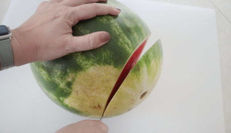 knife cutting bottom of watermelon
