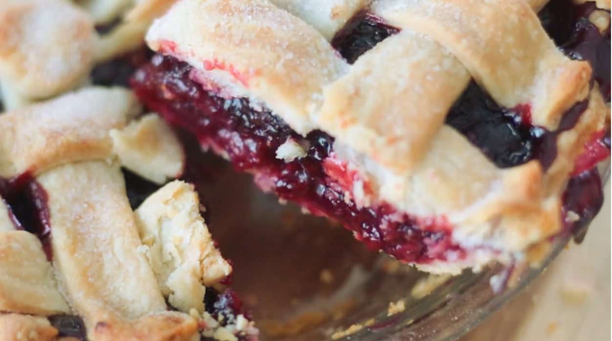 Slice of fresh cherry pie being served from pie.