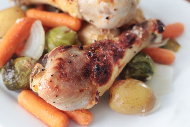roasted chicken legs on plate with vegetables