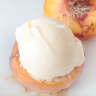 baked peaches and cream on a white plate