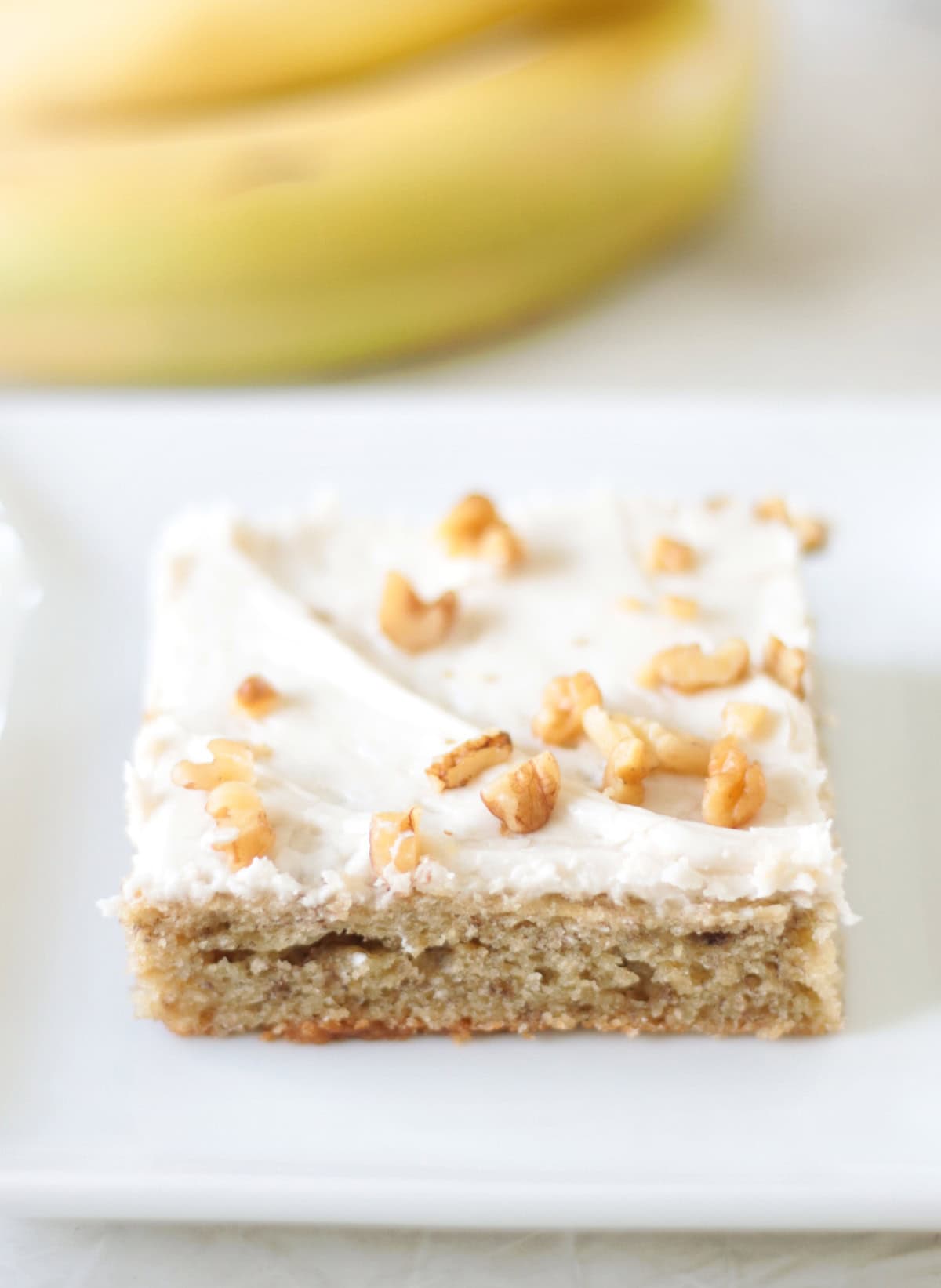 baba bar on white plate with bananas in the background