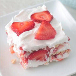 Slice of strawberry icebox cake on white plate