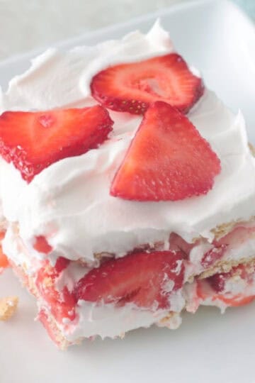 Slice of strawberry icebox cake on white plate