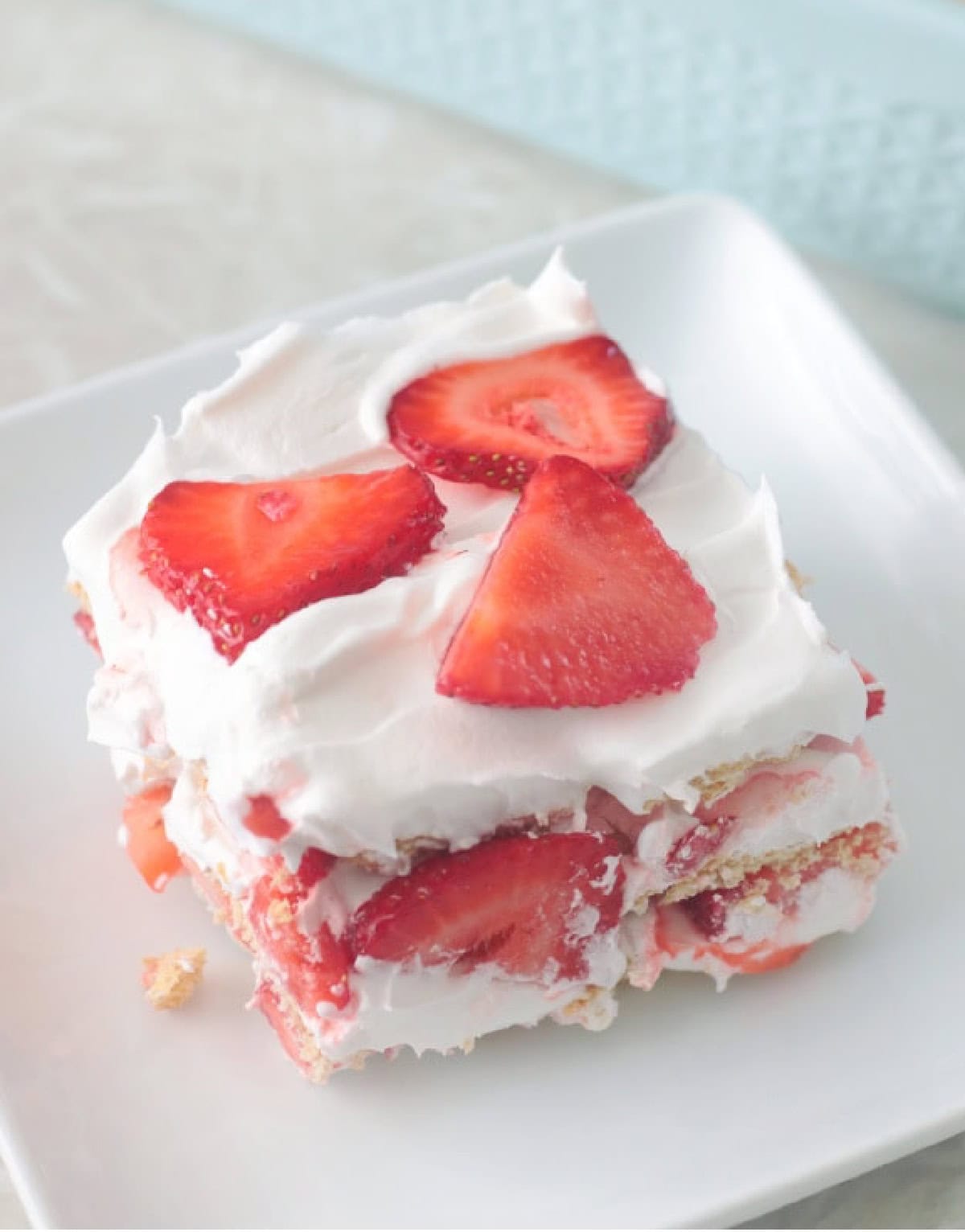 Slice of strawberry icebox cake on a white plate.