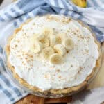 Full size banana cream pie with sliced bananas on top.