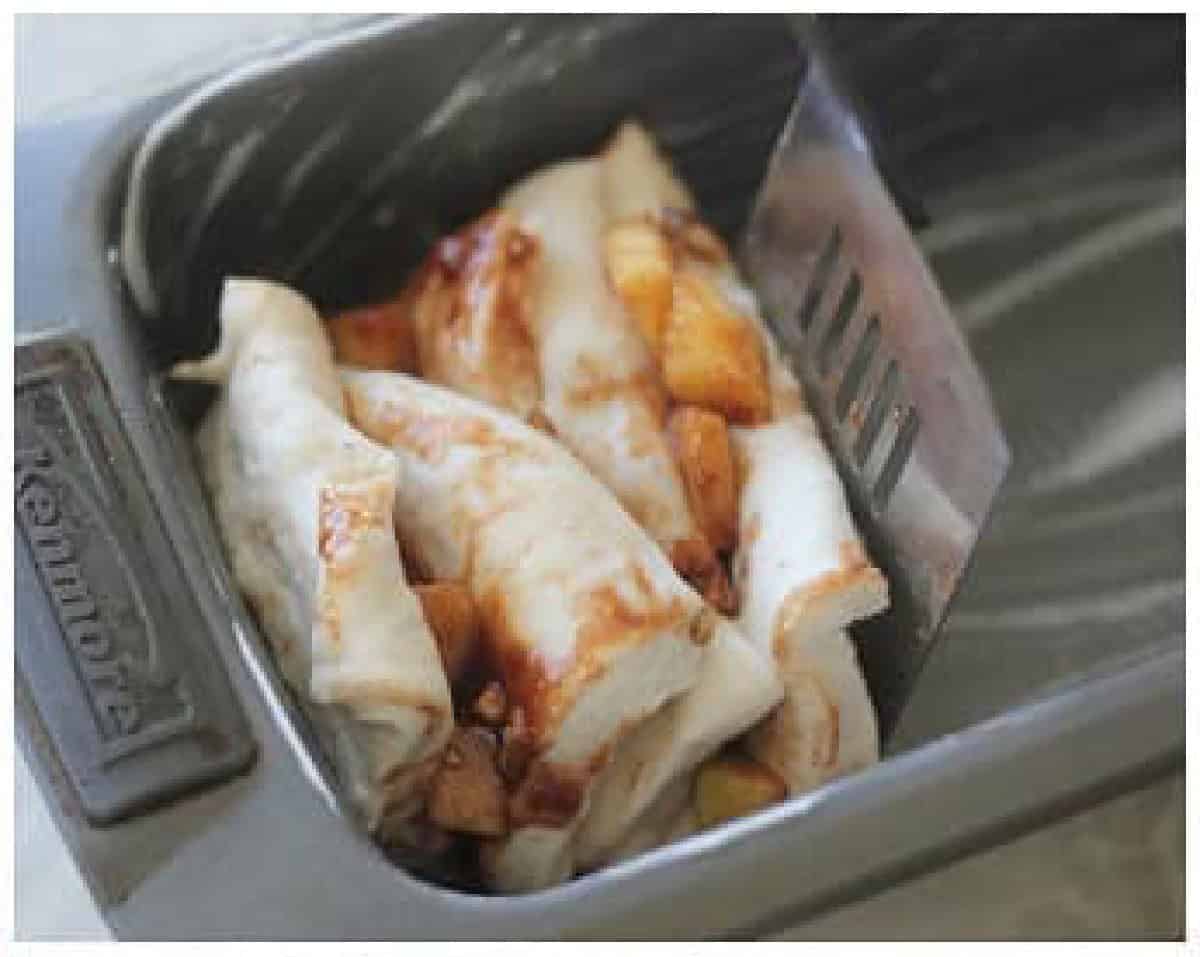 Slices of bread dough cut into squares, stacked and placed inside greased loaf pan.