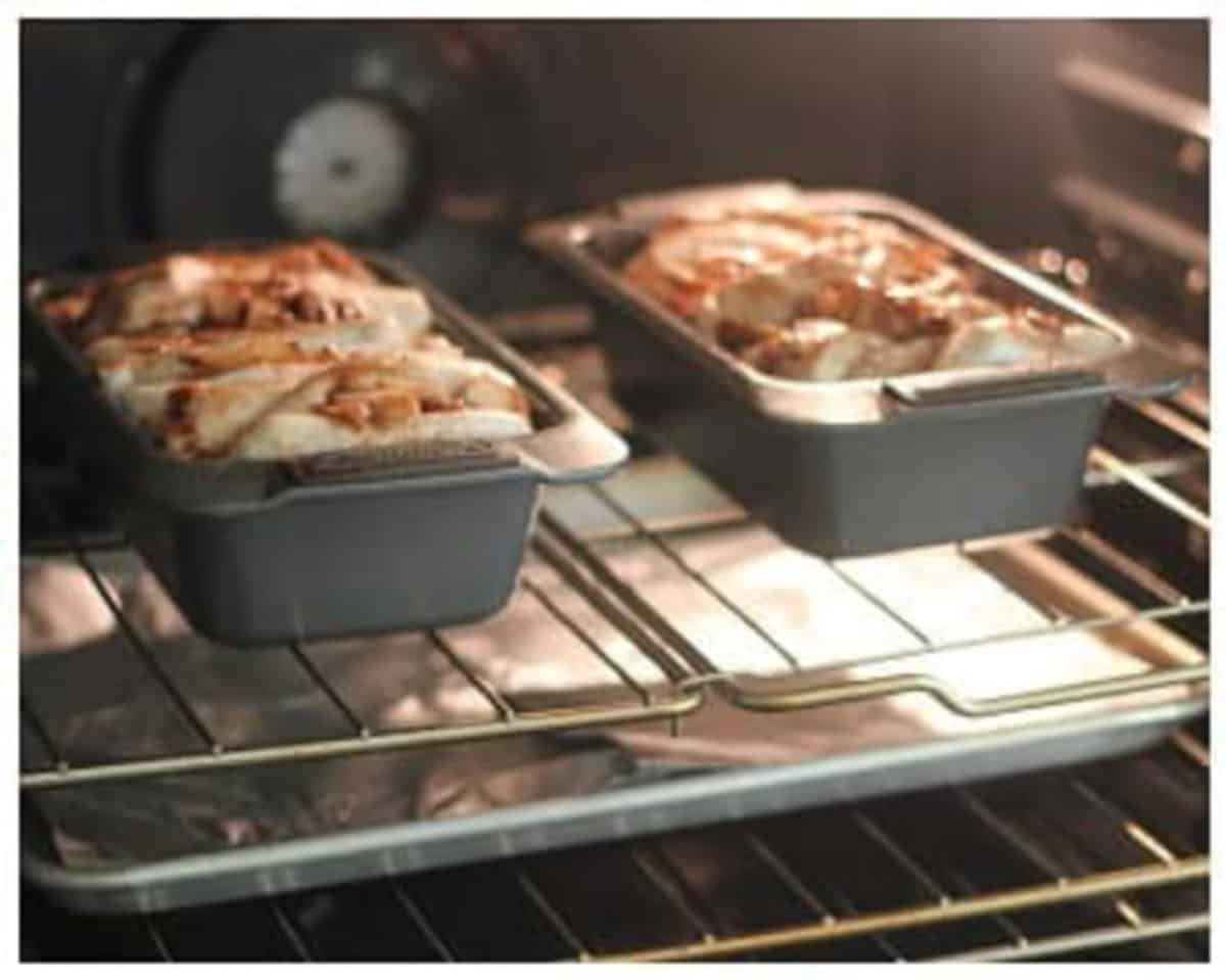 Two loaves of apple pull apart bread baking in oven.