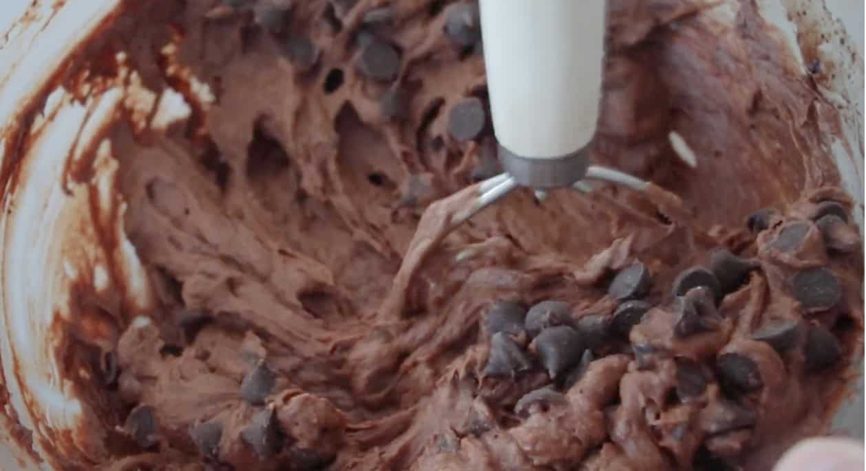 Dough whisk mixing chocolate pumpkin bread batter.