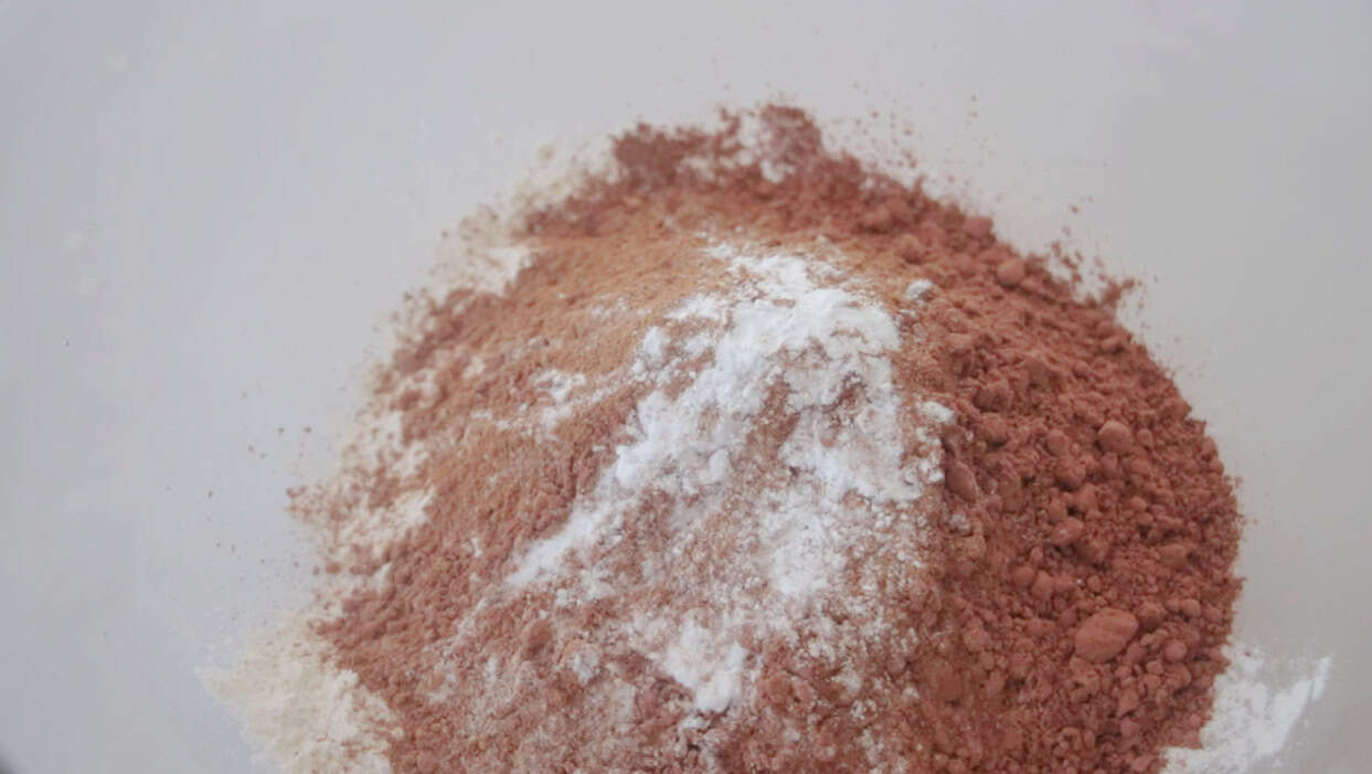 Mixing bowl with flour, cocoa powder, baking soda, salt, pumpkin pie spice.