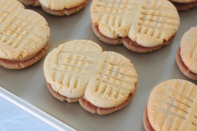 peanut shaped peanut butter sandwich cookies on baking sheet