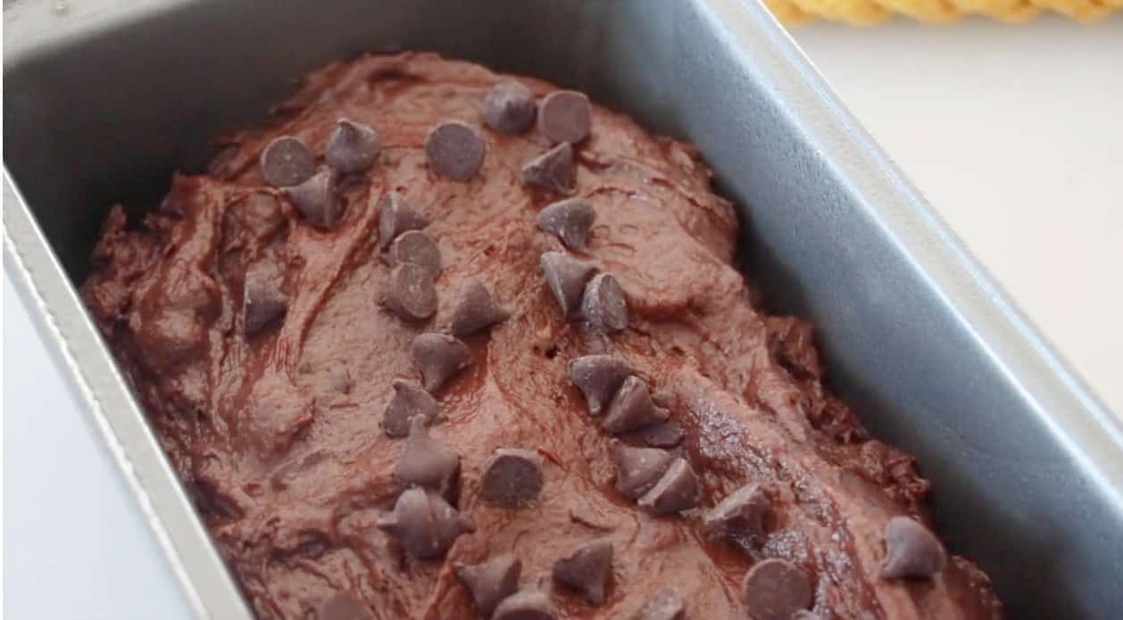 Loaf pan with pumpkin bread batter and chocolate chips.