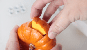 hand pulling out chunk of pumpkin