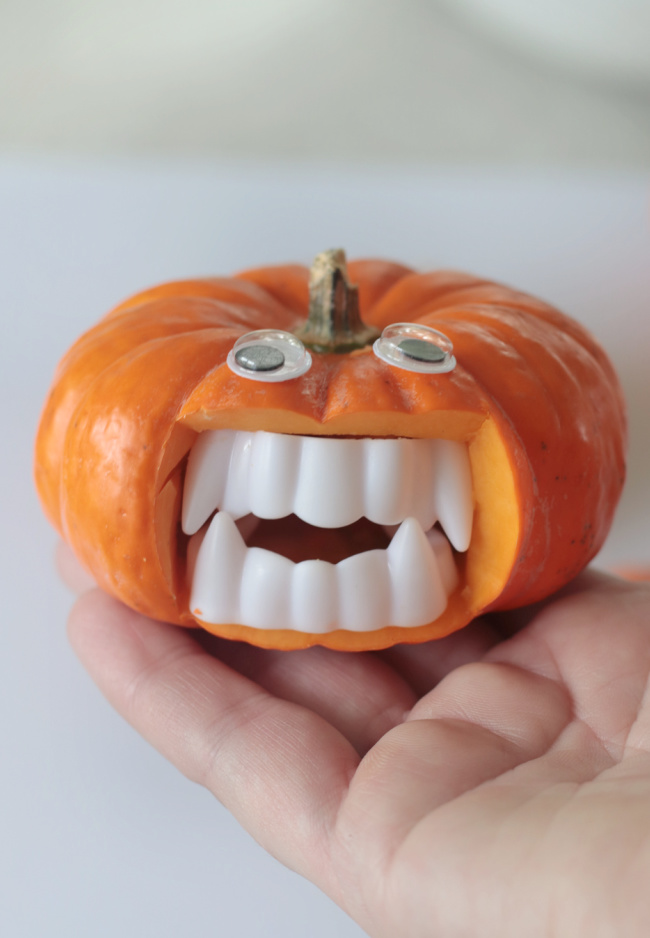hand holding mini vampire pumpkin