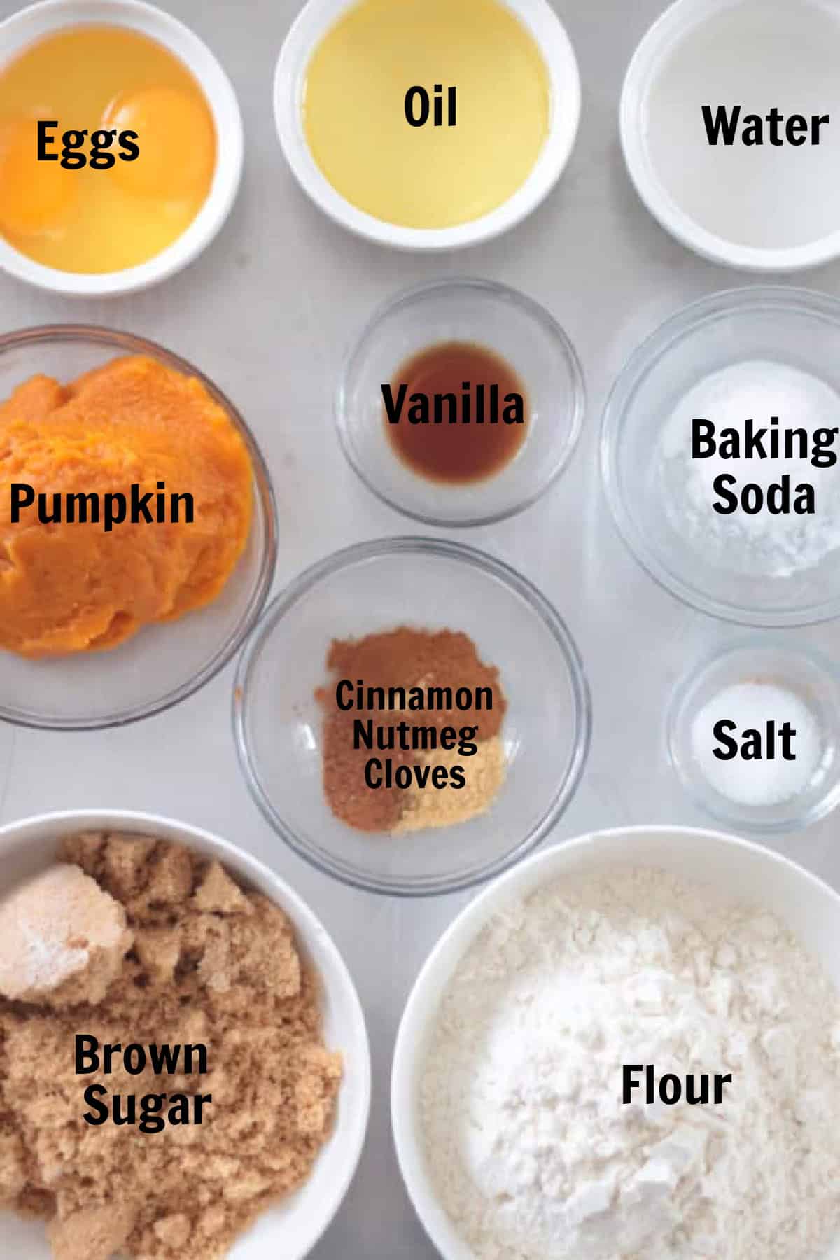 Bowls of eggs, oil, water, pumpkin puree, vanilla, baking soda, salt, spices, flour and brown sugar.