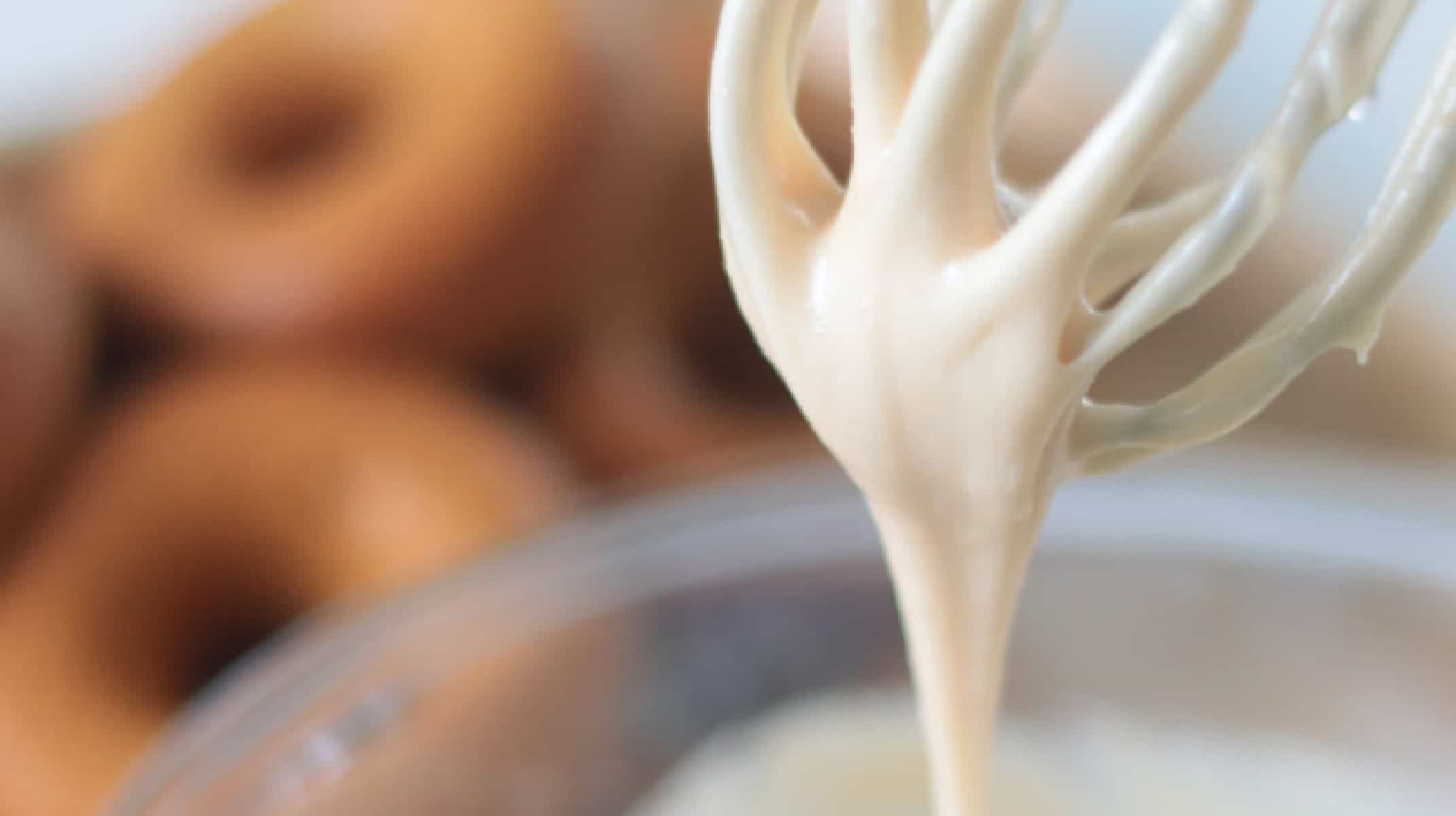Maple glaze dripping off of a whisk.