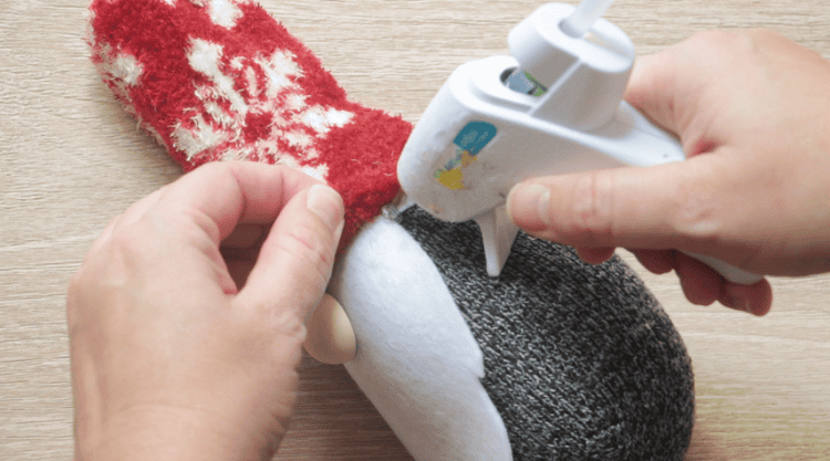 hot glue attaching hat on sock gnome