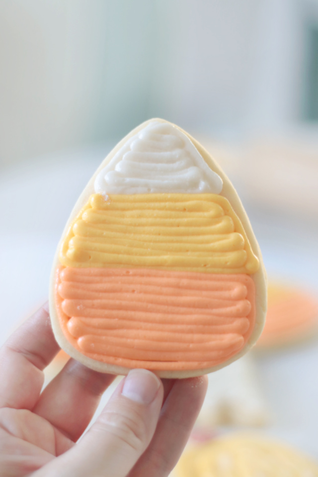 hand holding candy corn sugar cookie
