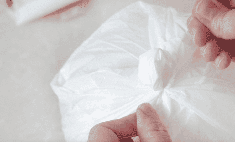 Hands tying fishing line onto trash bag ghost.