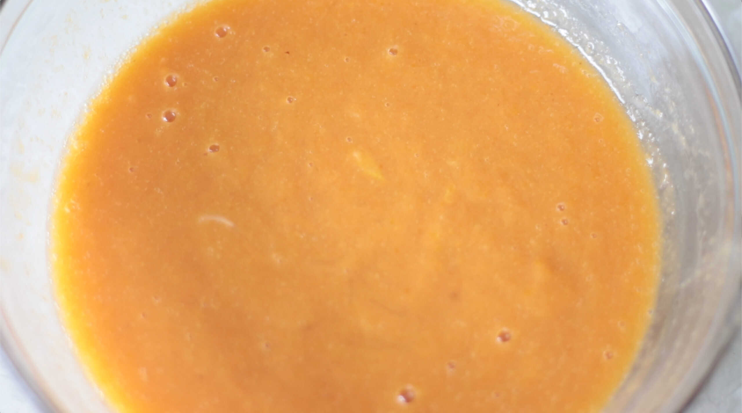 Wet ingredients for pumpkin bread in glass mixing bowl.