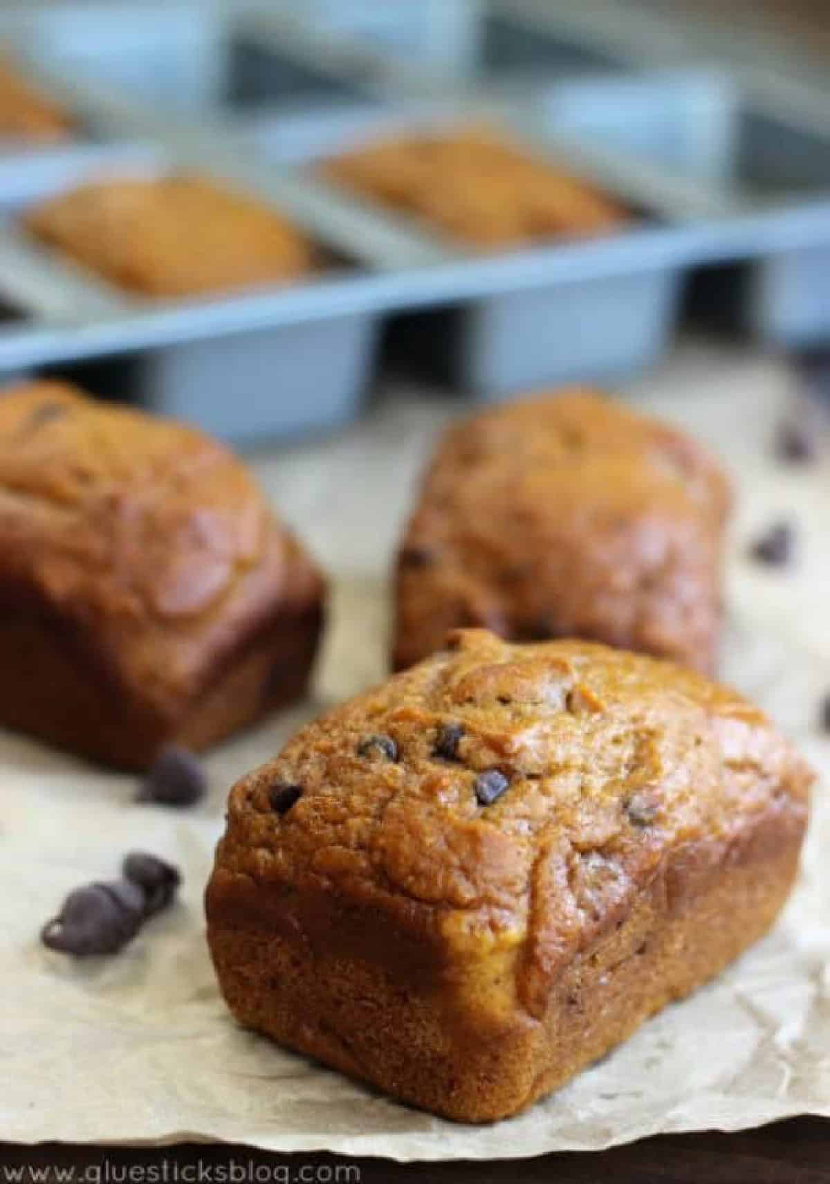 3 mini loaves of pumpkin bread on parchment paper.