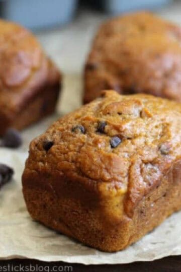 3 mini loaves of pumpkin bread on parchment paper.