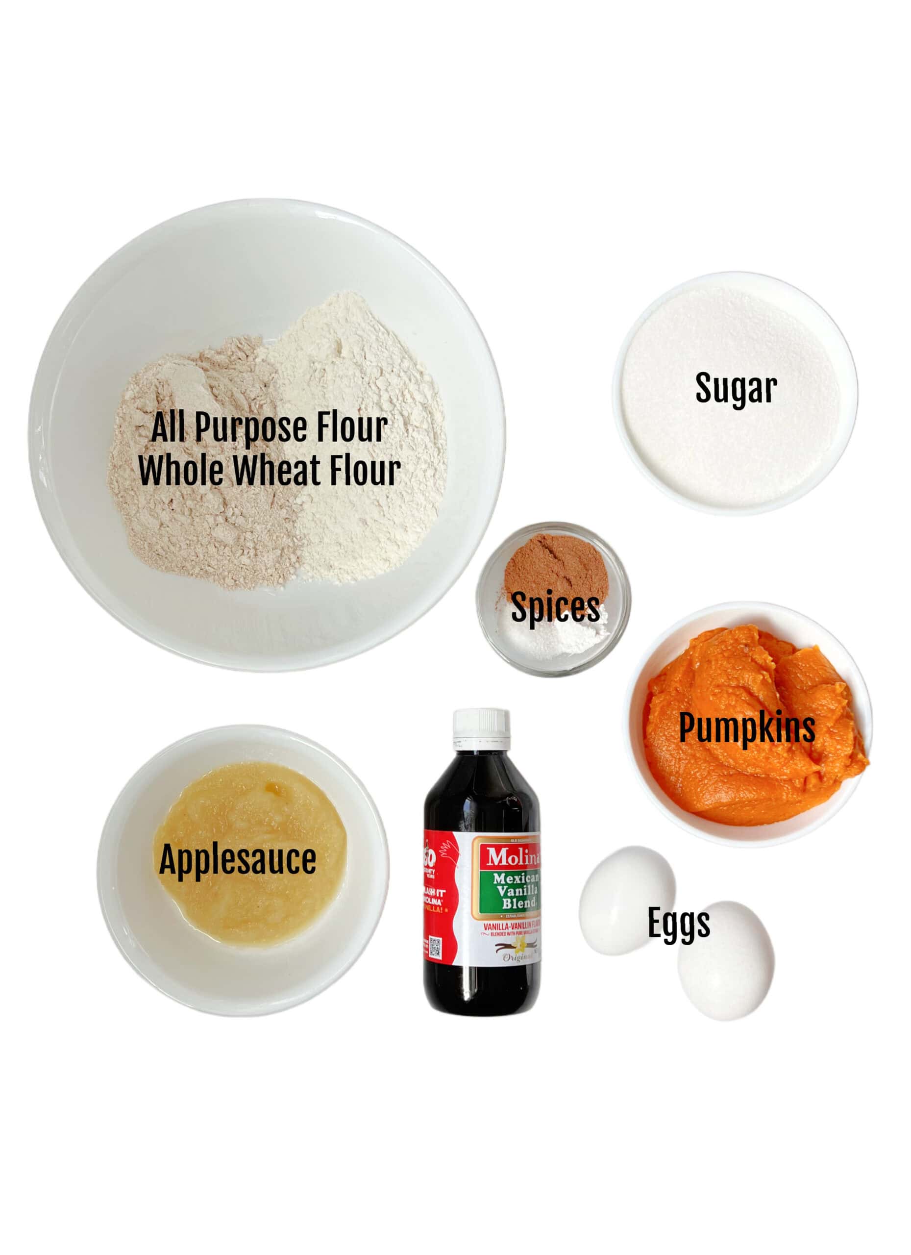 Bowls of wheat flour, all purpose flour, sugar, spices, pumpkin puree, applesauce, vanilla and eggs.