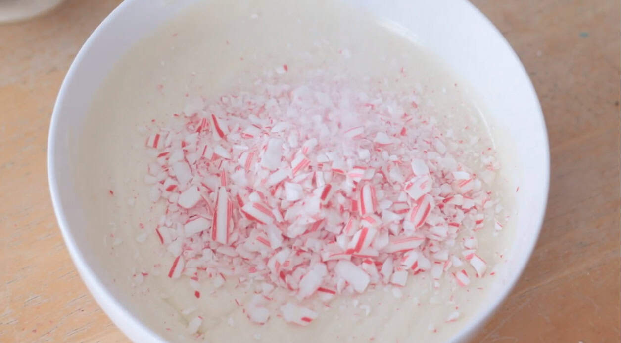 Bowl of melted white chocolate and crushed candy canes.