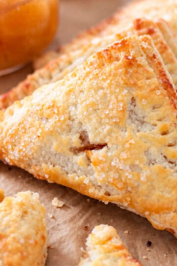 Apple turnovers on brown parchment paper.