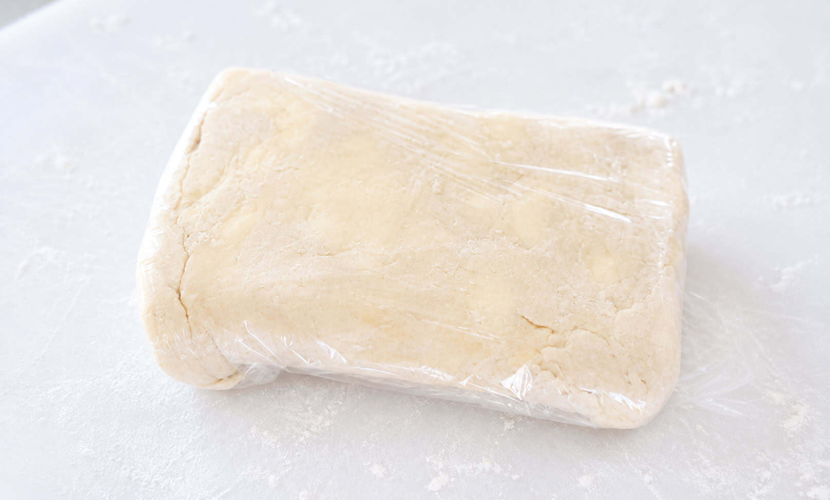 Puff pastry dough covered in plastic.