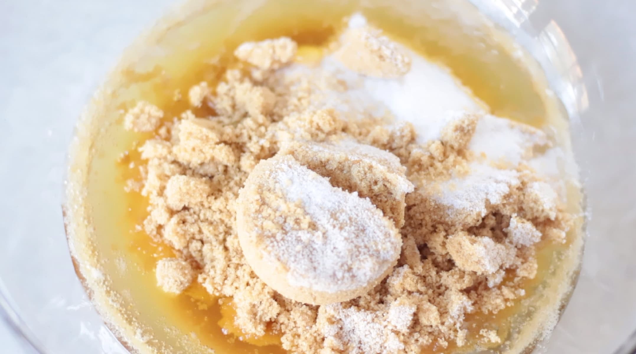 Brown butter, white sugar and brown sugar in glass mixing bowl.