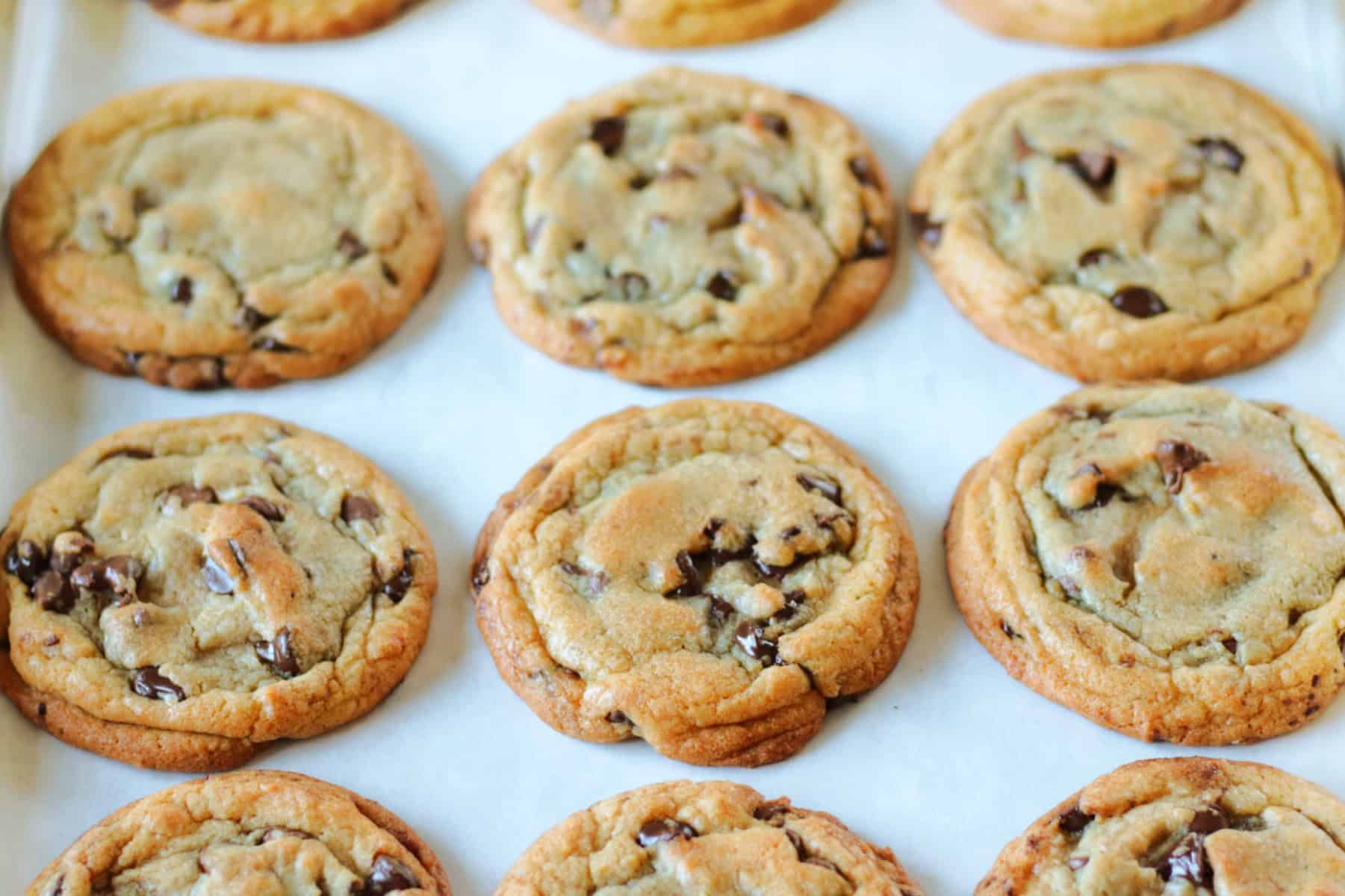 Brown butter chocolate chip cookies on parchment paper.