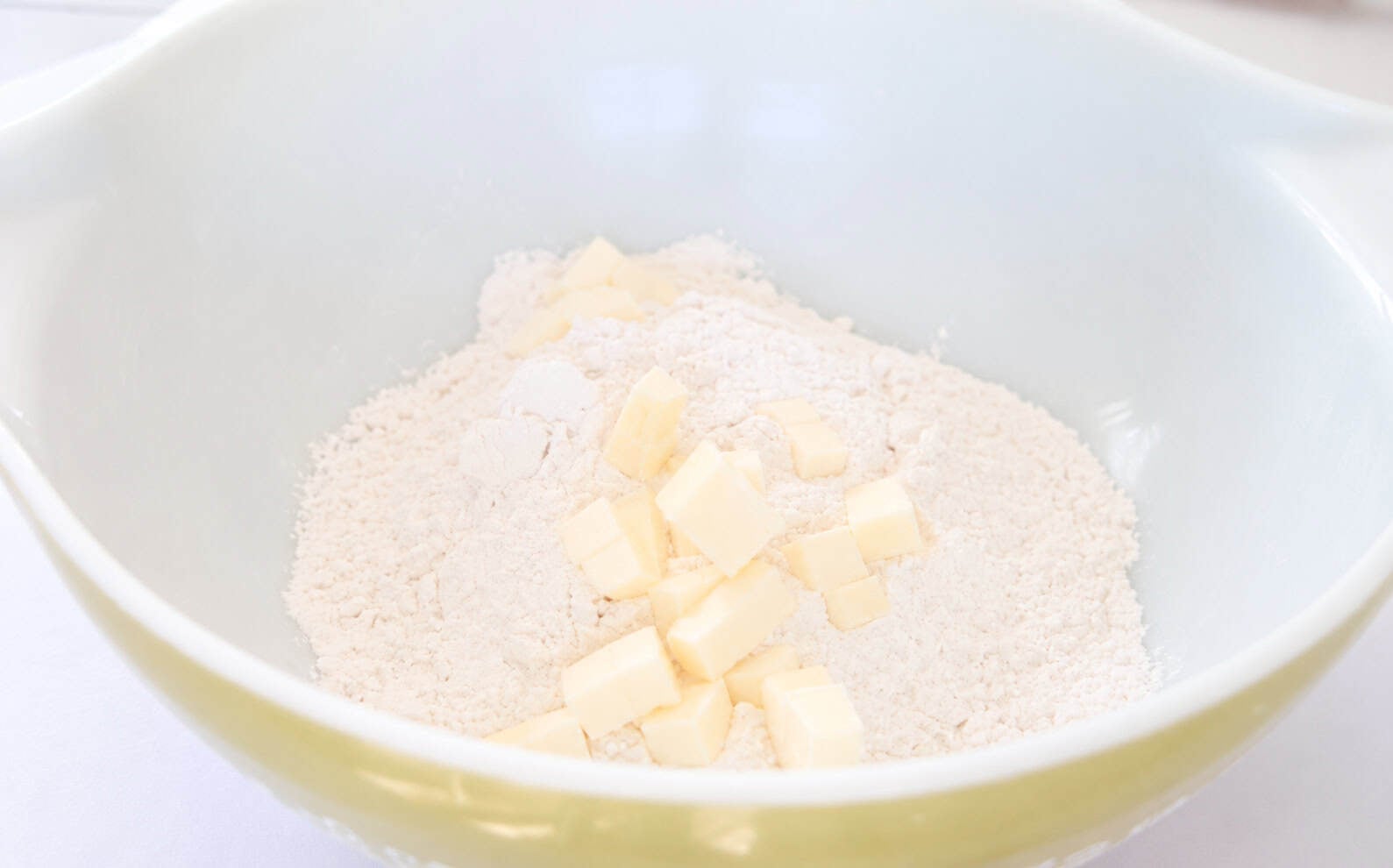 Bowl of flour and diced butter cubes.