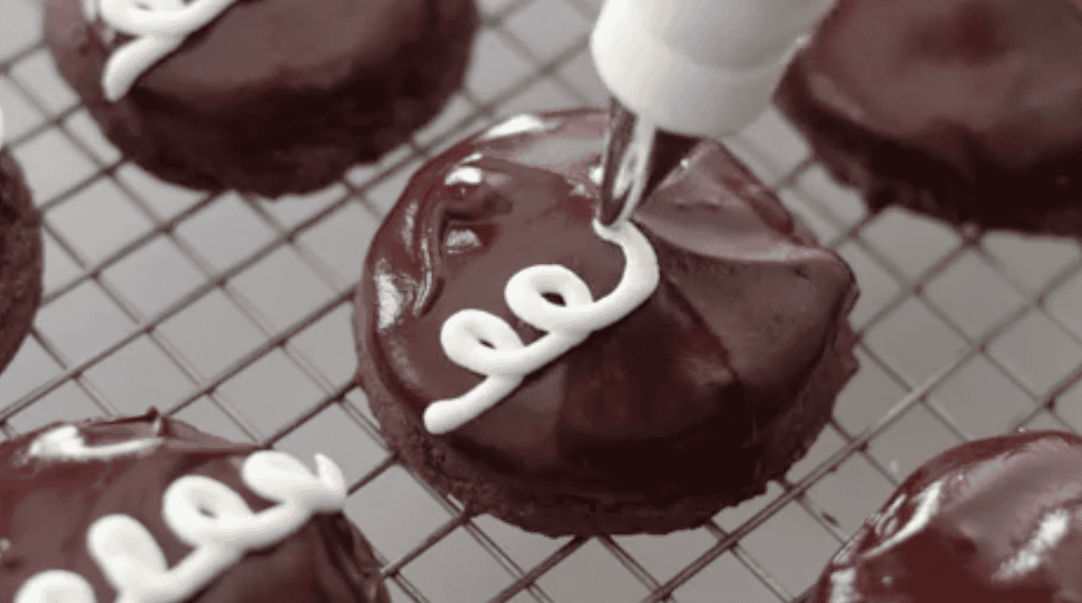 Squiggles piped over chocolate cookies.