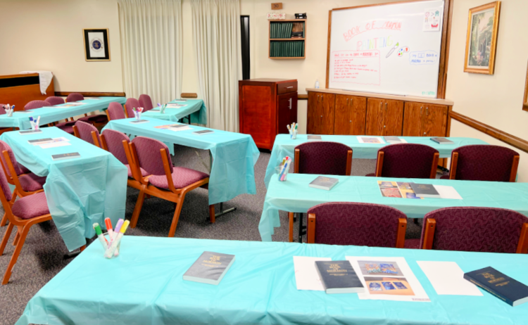 tables covered with plastic table cloths and copies of the Book of Mormon