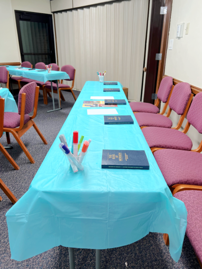 table with paint markers and copies of the Book of Mormon