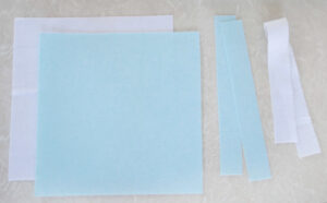 two squares and two strips of blue and white felt