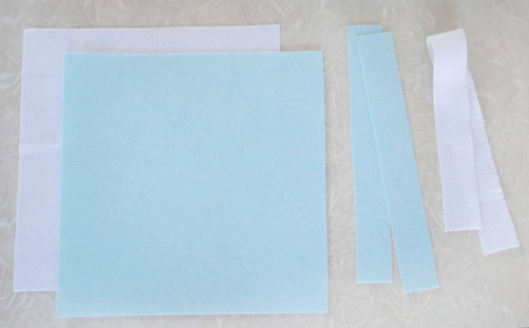 Two squares and two strips of blue and white felt.