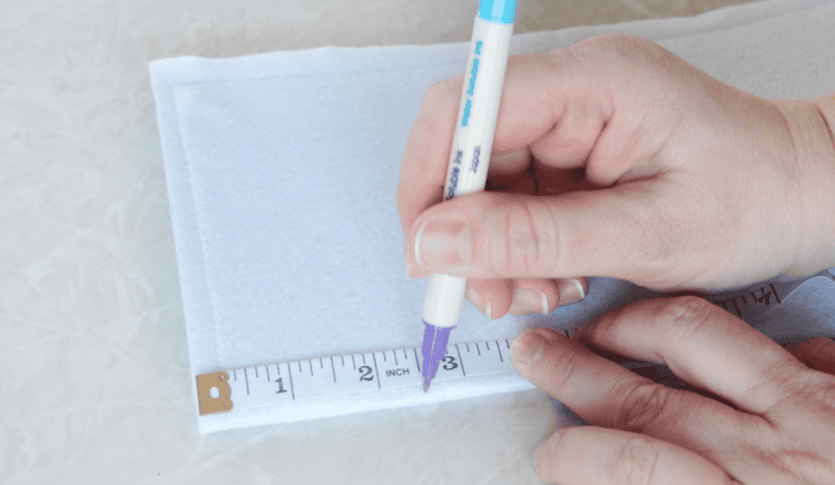 Hand marking 2.5" point on fabric.