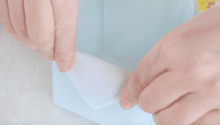 Hands folding over flap on easter basket.