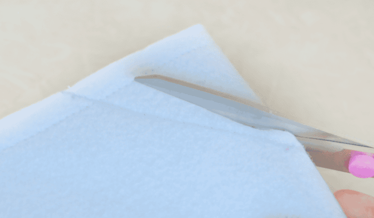 Scissors cutting off excess fabric in corners.