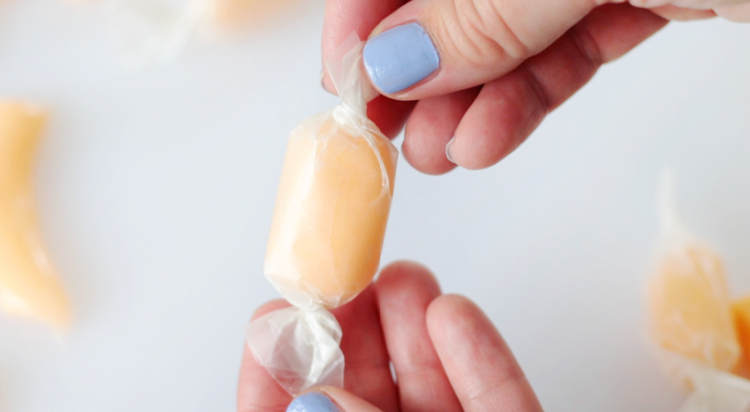 hand holding wrapped piece of homemade taffy