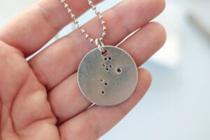 hand holding finished constellation necklace