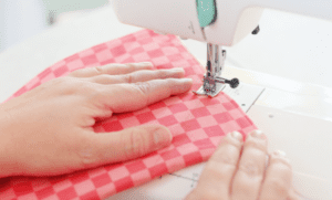 sewing machine and orange checked fabric sewn at the corners