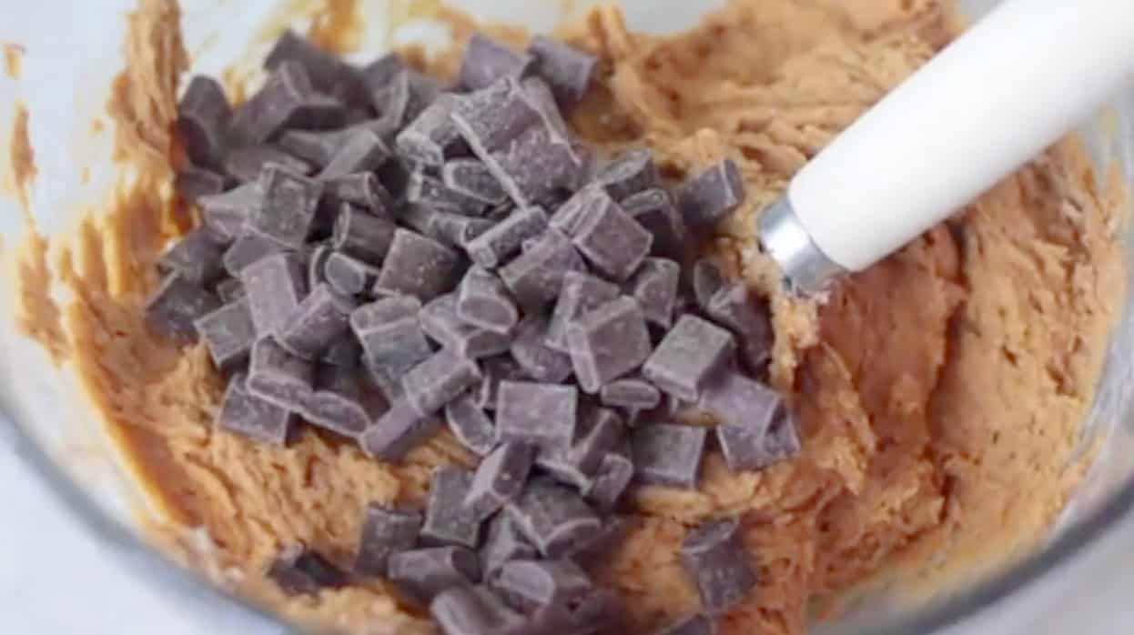 Pumpkin cookie dough with chocolate chunks in mixing bowl.