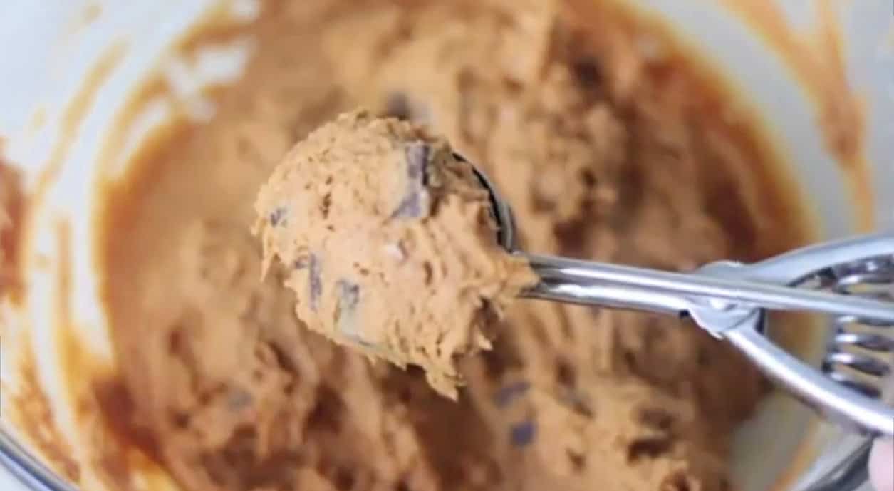 Scoop of pumpkin cookie dough in cookie scoop.