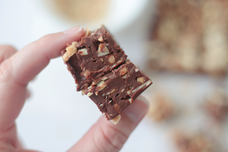 fingers holding two squares of fudge