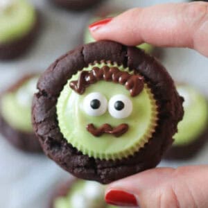 Hand holding chocolate Frankenstein cookie.