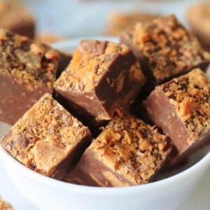White bowl of squares of butterfinger fudge.