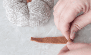 brown strip of felt being rolled up by hand